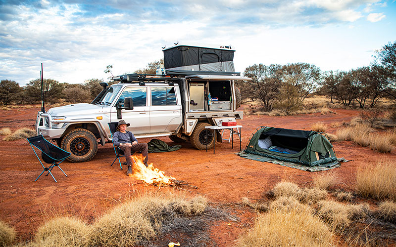 Man Camping In Front Of Fire with Dual Battery Setup in 4x4