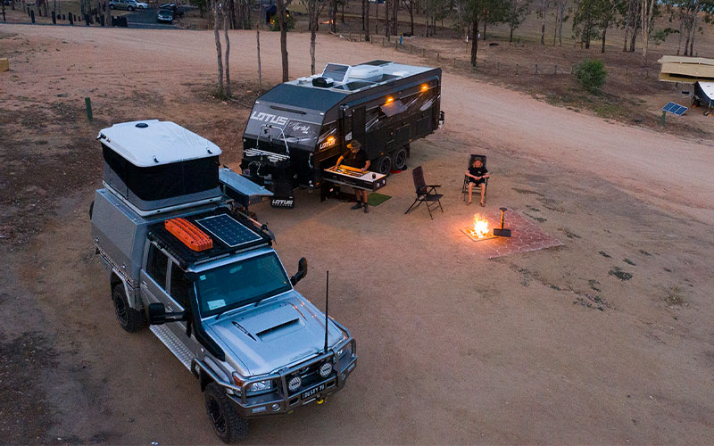 Man Camping In Front Of Fire with Inverter in 4x4